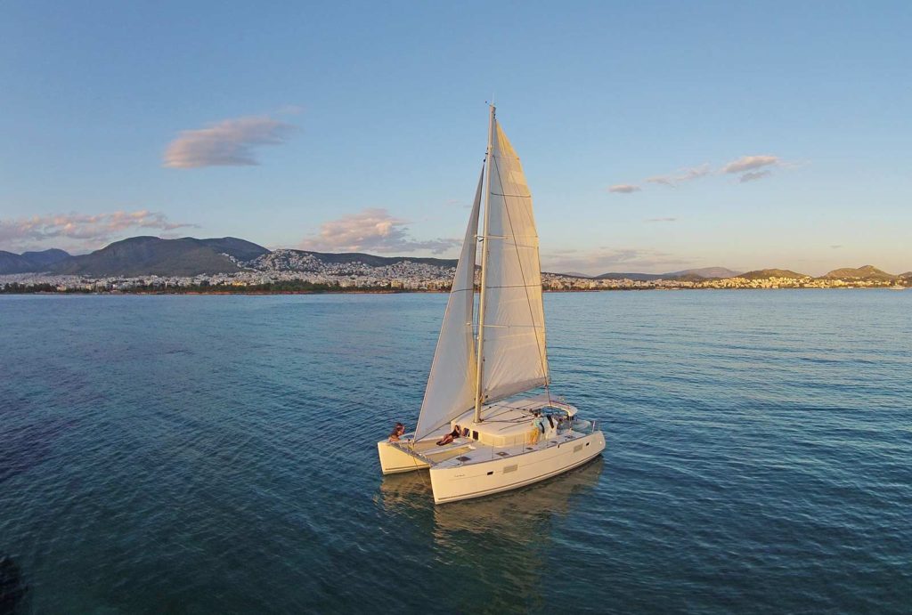 Sailing in Athens Greece with catamaran cruise boat tour with people on the catamaran boat during sunset