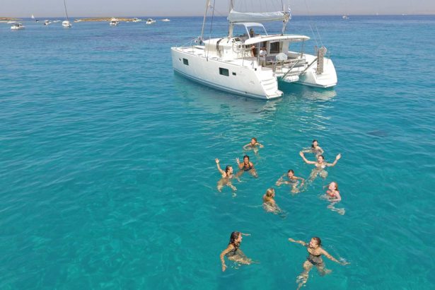 Girls having fun in the aqua blue waters in Athens Greece near a catamaran boat cruise tour vacation 2024